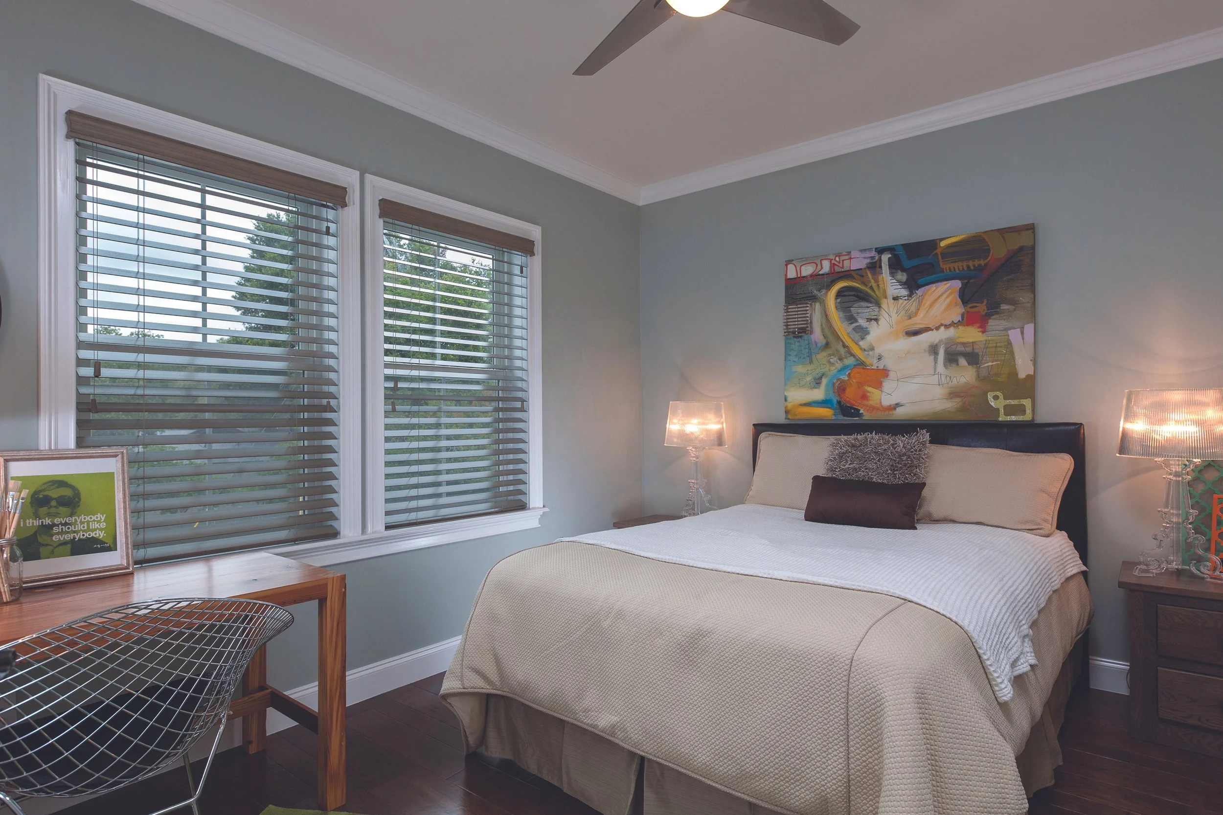 Wood blinds in a bedroom over a desk