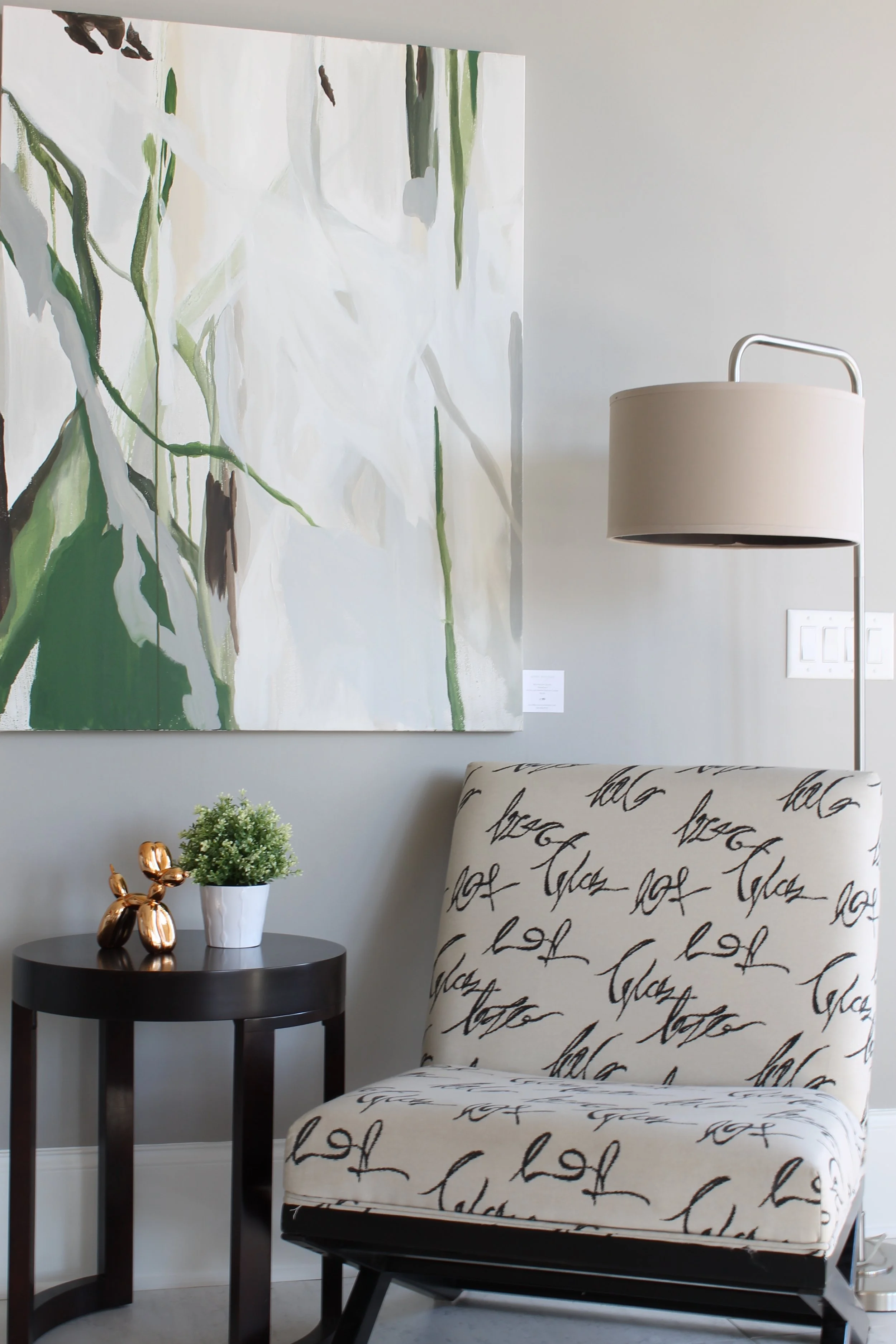 sitting nook with art work and accent chair floor lamp