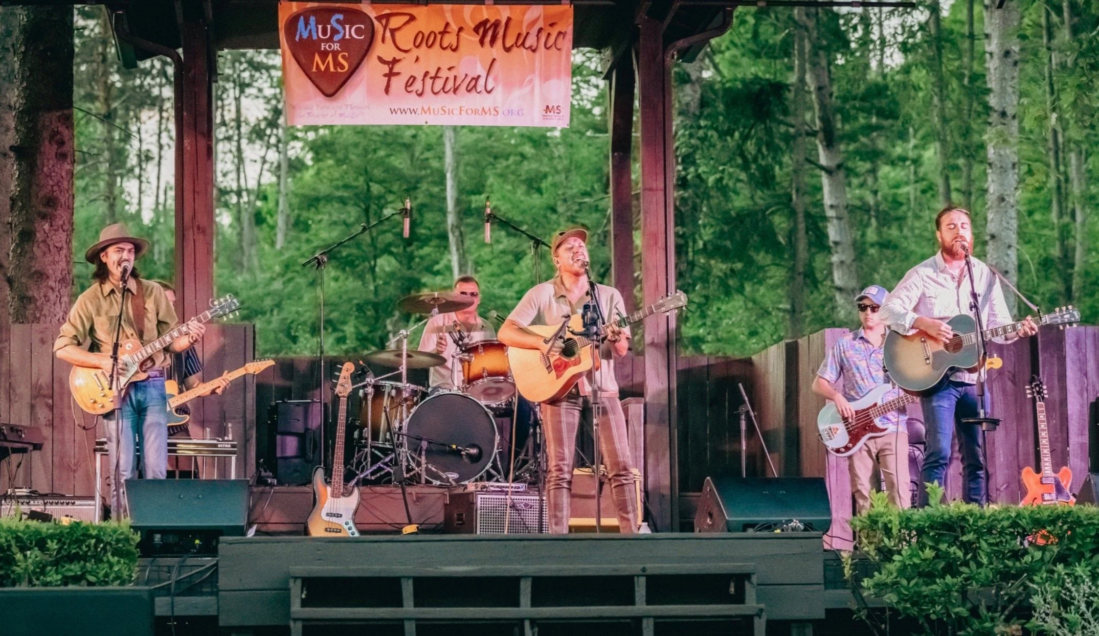 Outdoor music festival with band performing on stage.