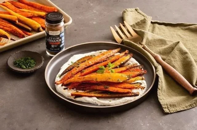Honey roasted cinnamon carrots arranged on top of a delicious pureed base in a beautiful warm environment.