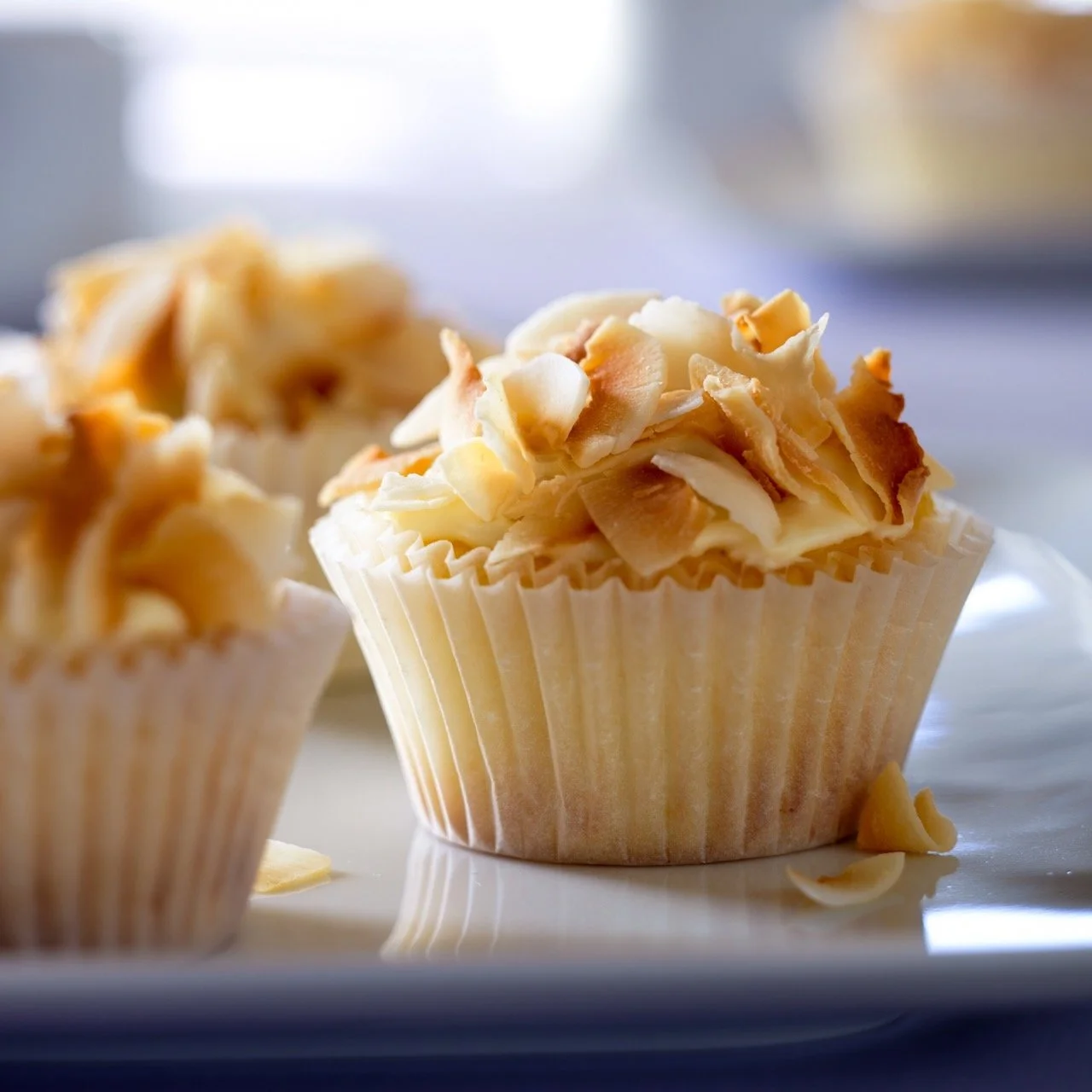 Cupcake topped with white icing and toasted coconut