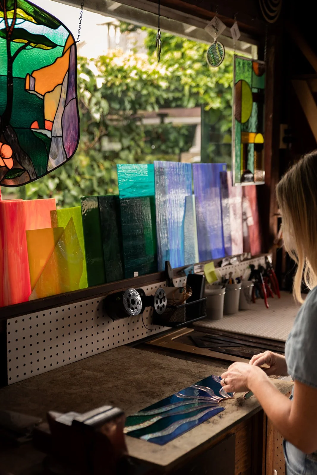 Artist Erica of Brightfire Artworks working in her stained glass studio located in Pacific Grove, California