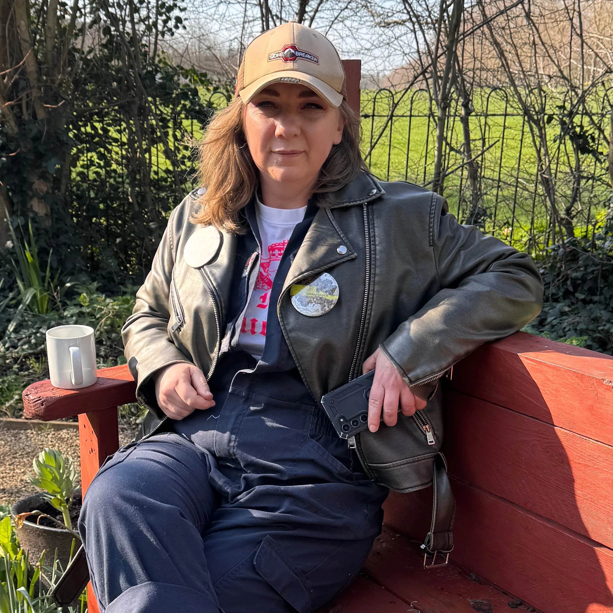 Jess Turtle sitting on a bench in the Museum of Homelessness garden