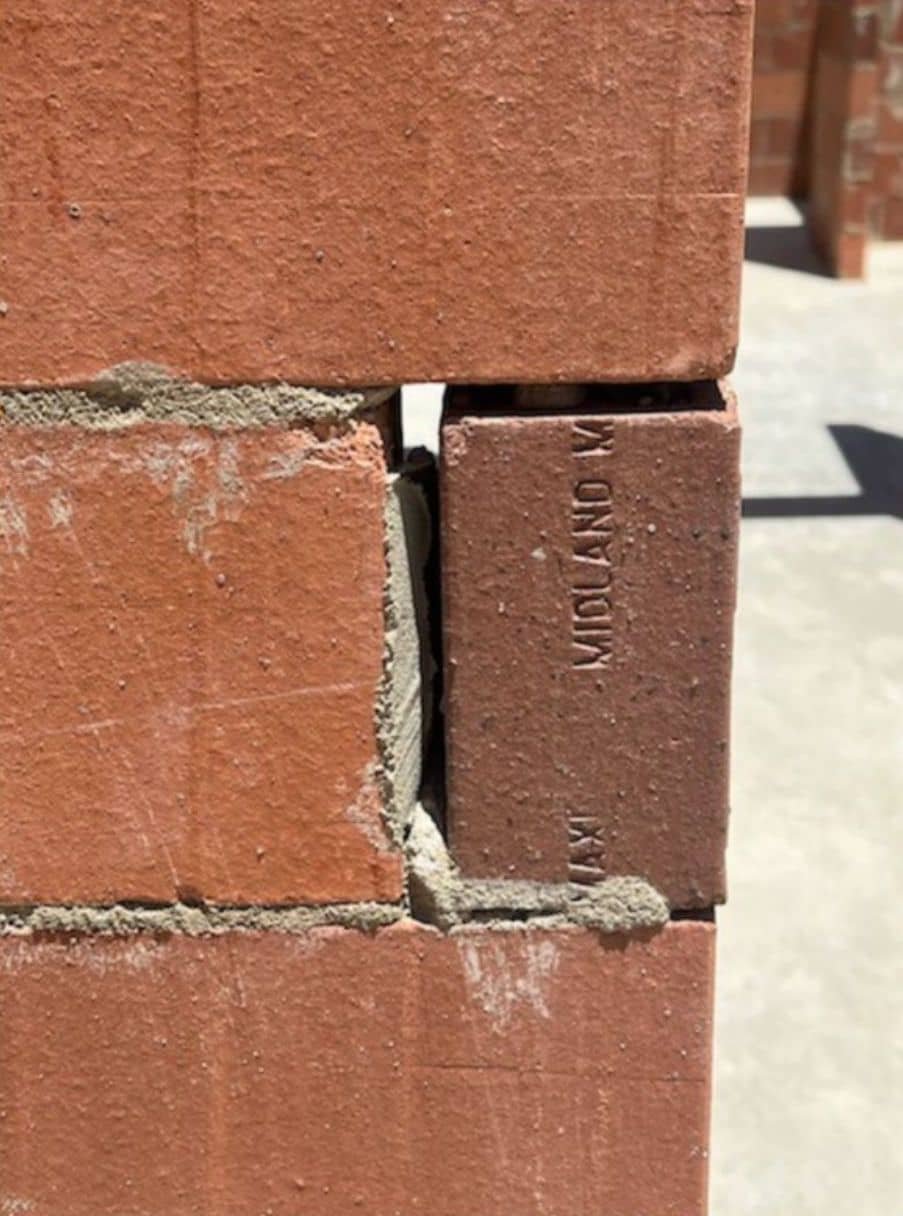 Inspector Measuring Brick Alignment for Proper Standards