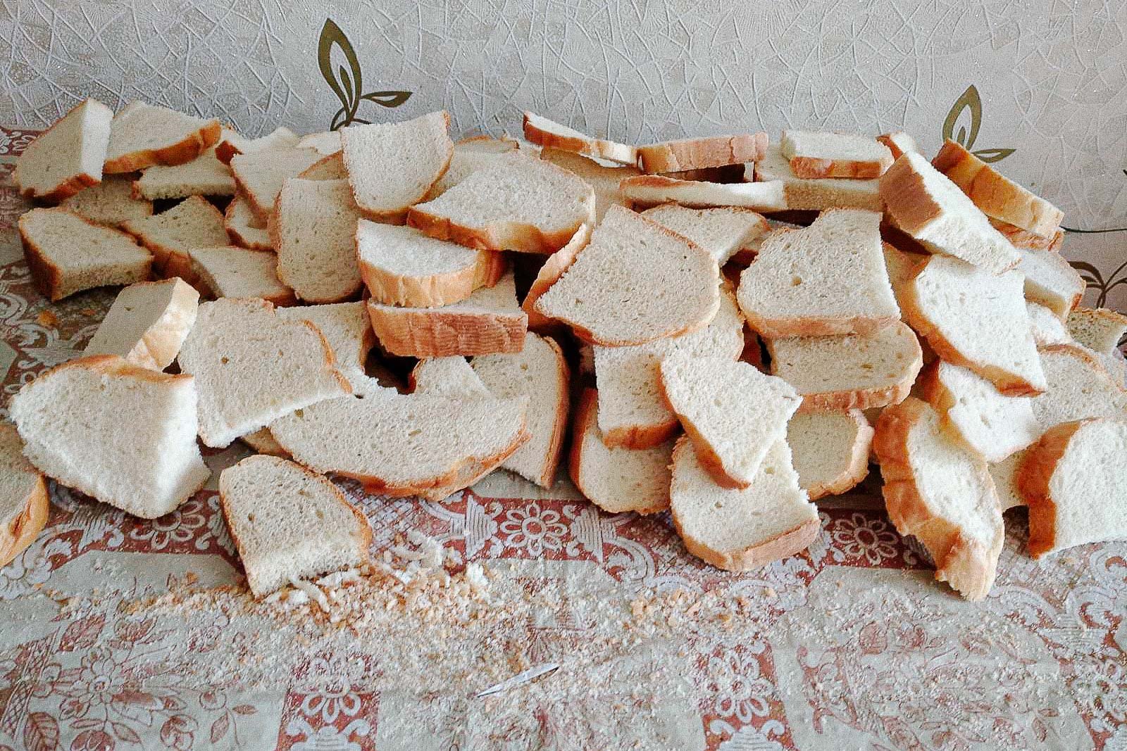 Broken bread slices scattered on a table with a floral pattern.