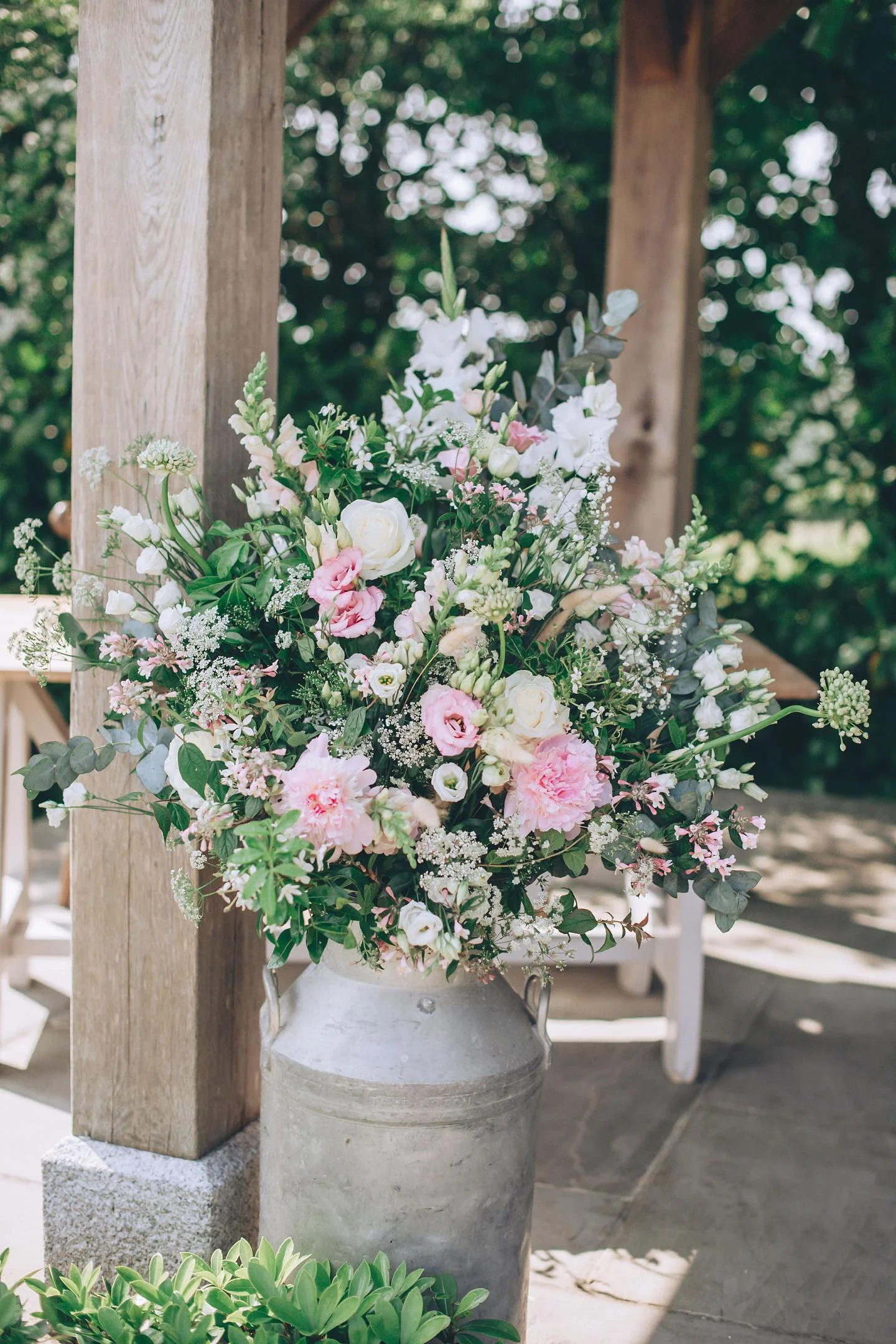 pretty pinks and greens in a milk churn