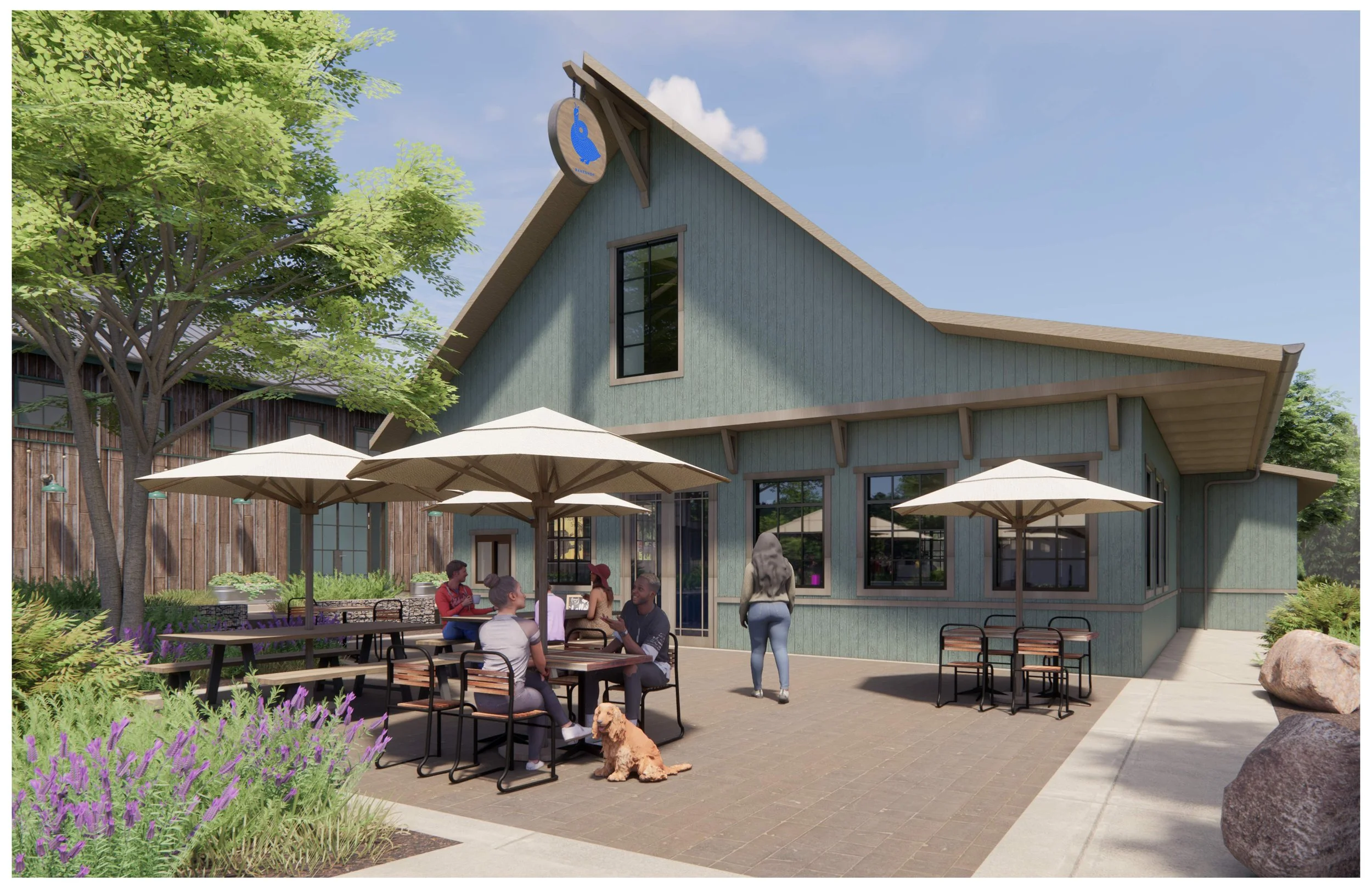 People sitting and standing outside a rustic, teal-colored bakery building with outdoor tables and umbrellas, a woman taking a photo, and a dog lying on the ground.