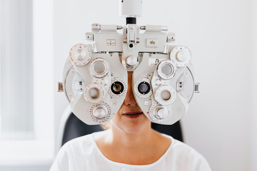 Woman having her eyes tested using a phoropter to determine prescription for hyperopia