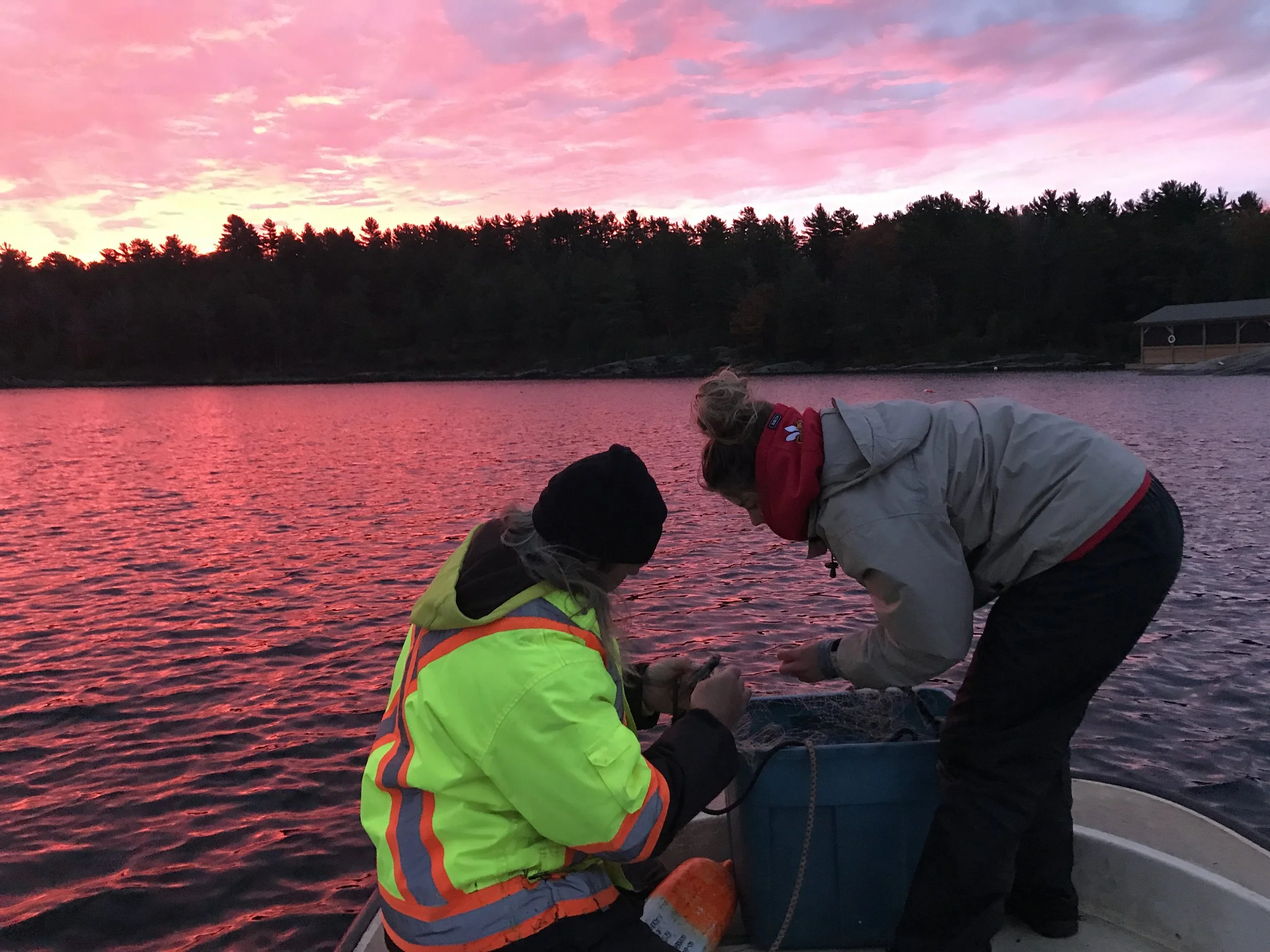 Two students on a fishing boat at sunset