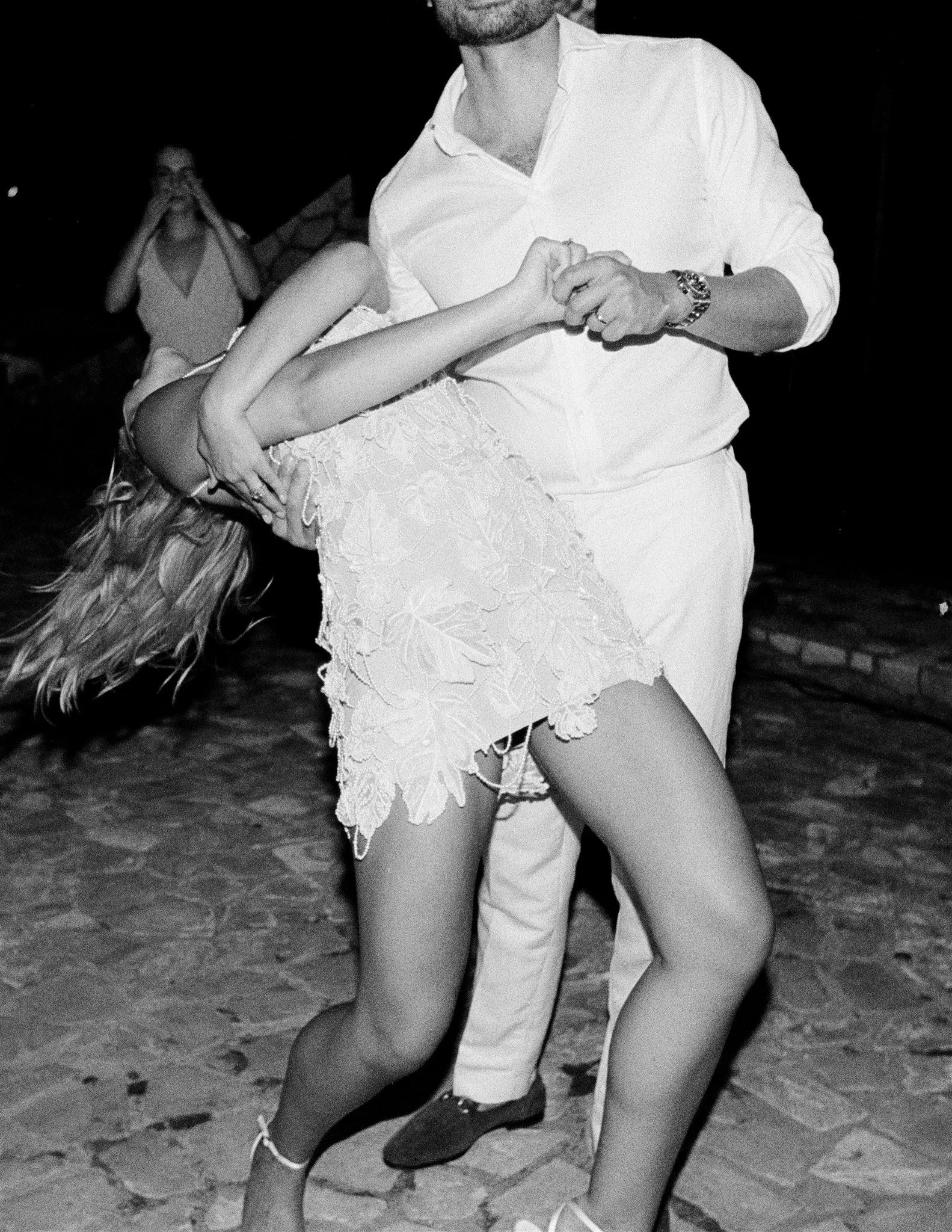 A man and woman dancing closely, with the woman leaning back and the man holding her.