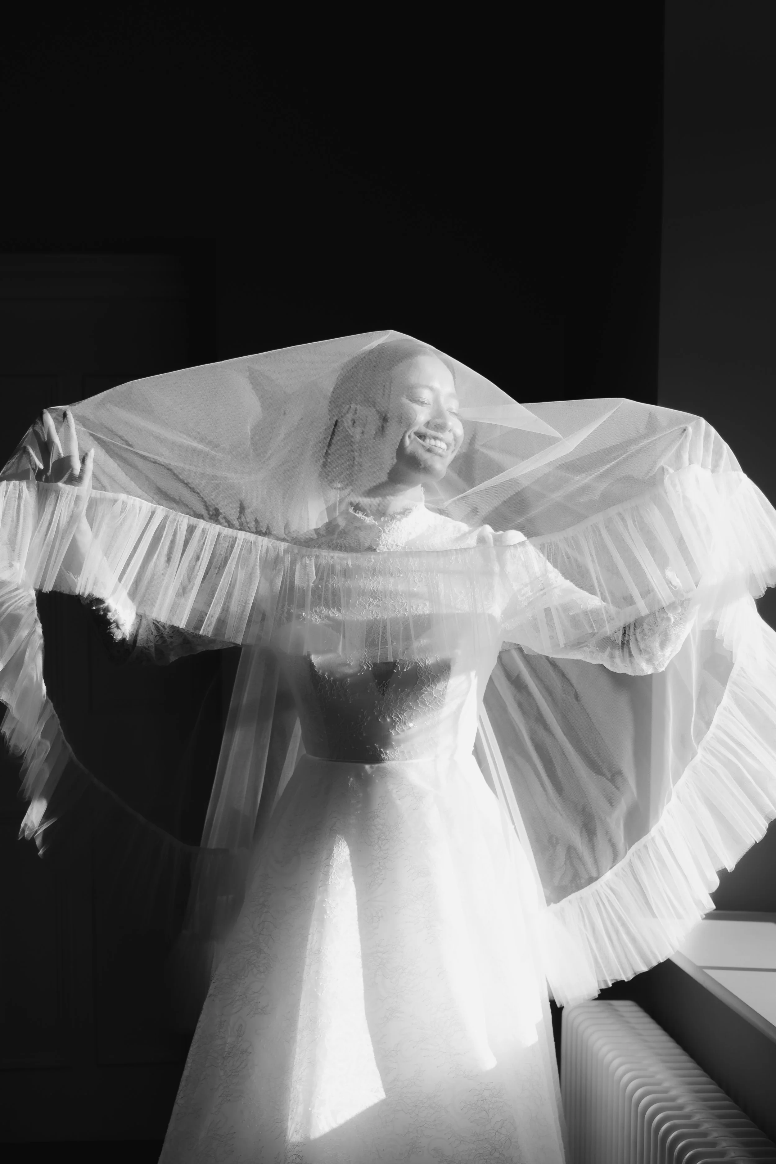A fashion-led bridal portrait, focusing on movement, texture, and the sculptural quality of the veil.