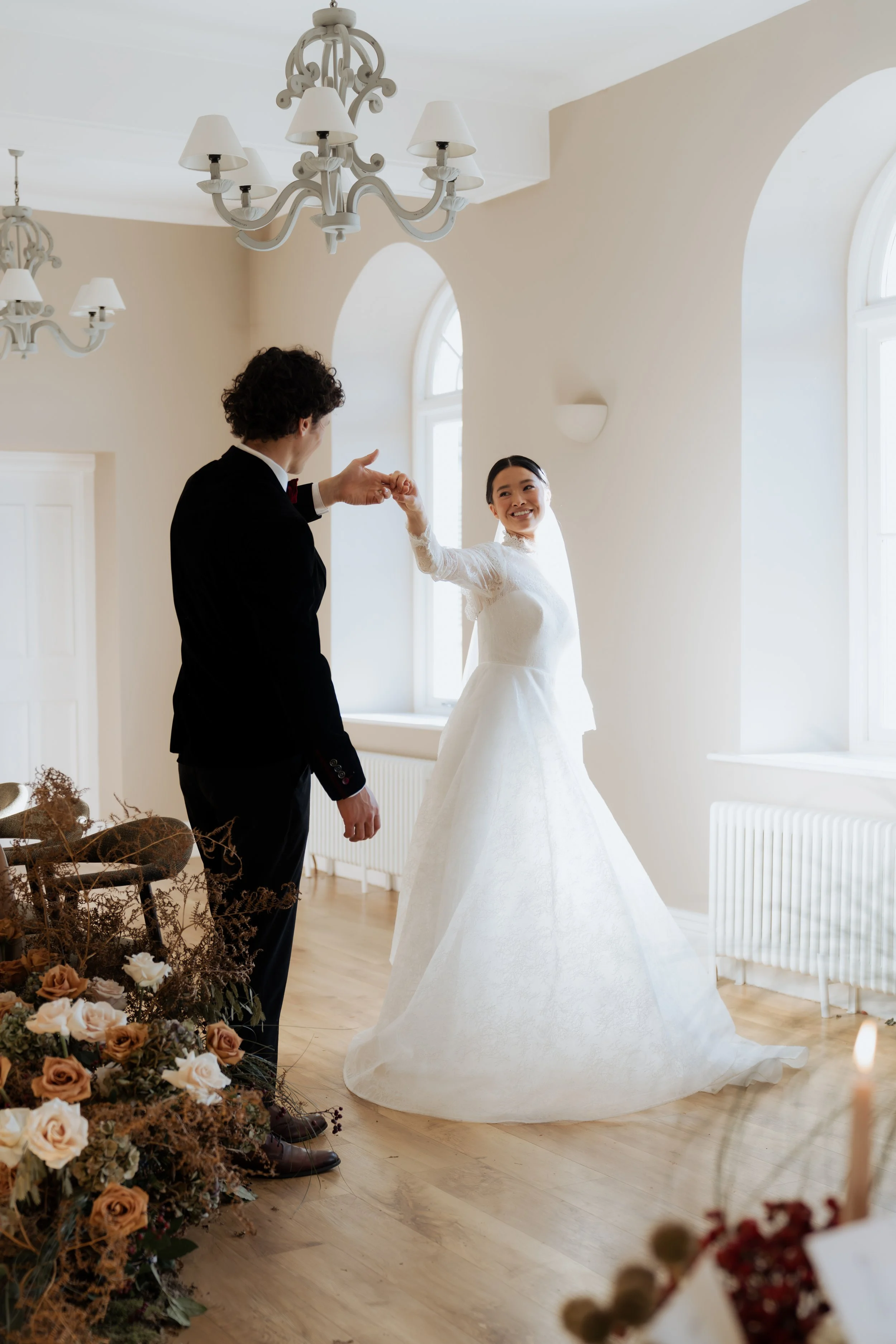 Editorial wedding photography in the Lake District featuring a bride and groom dancing in soft natural light, captured in a refined, timeless style