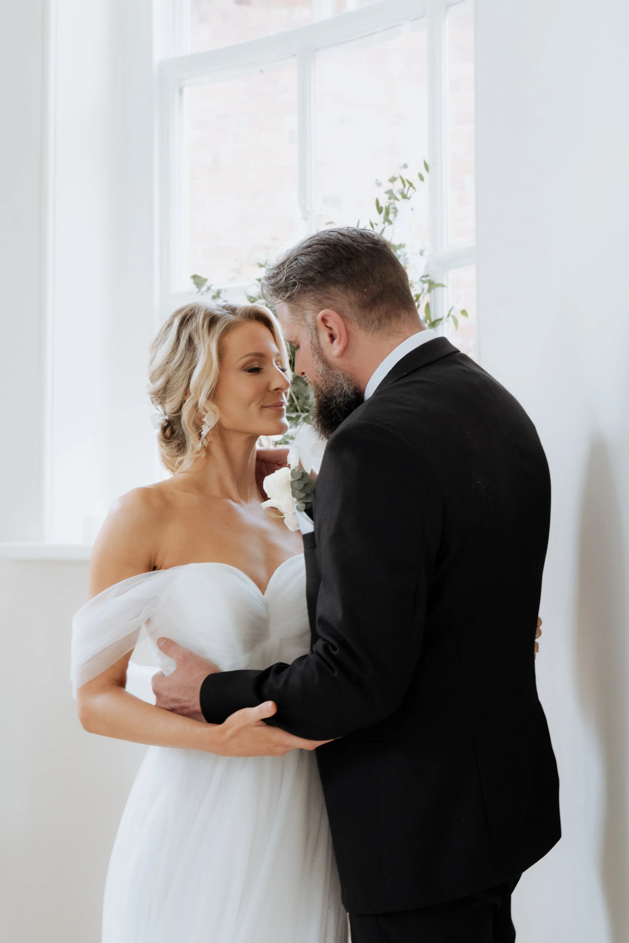 Intimate editorial wedding portrait of a bride and groom in soft window light inside Iscoyd Park, Shropshire.