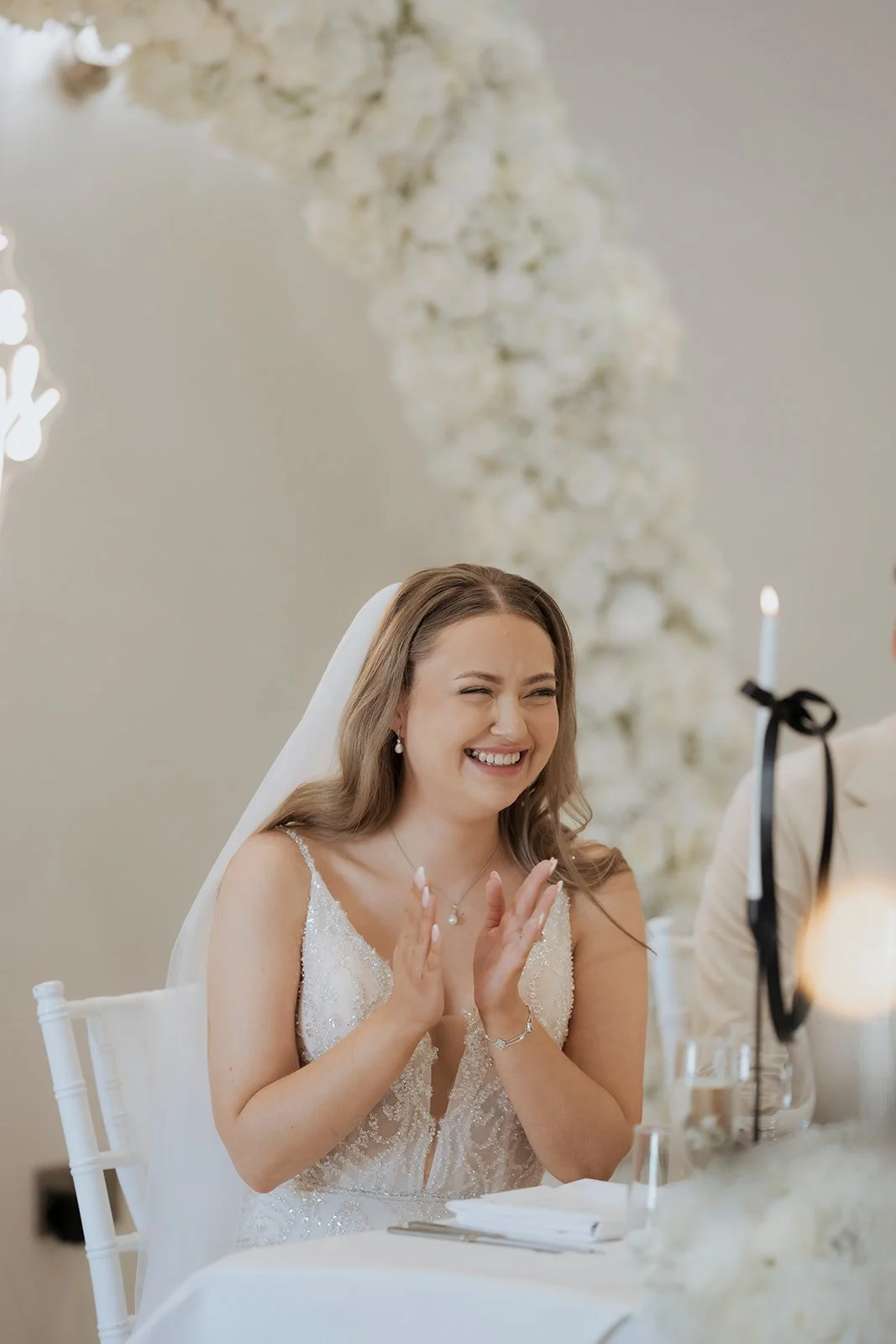 Bride laughing during wedding speeches, captured in a natural editorial style ideal for elegant Cheshire venues such as Hawkstone Hall.