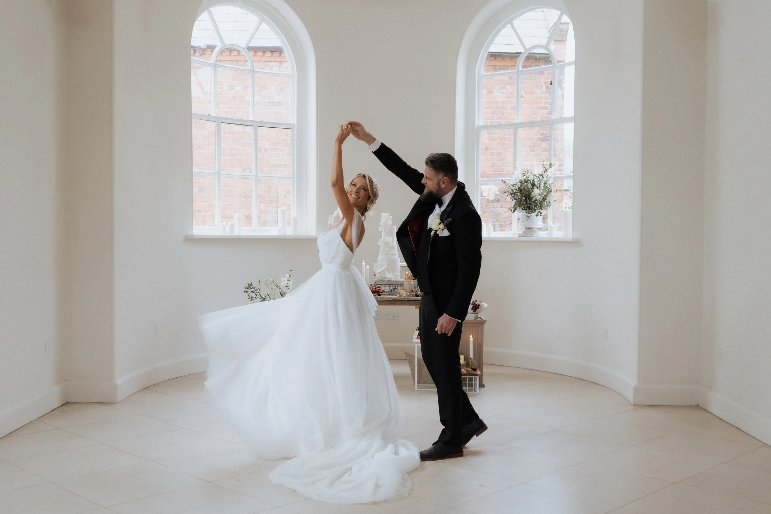 Bride twirling in a light-filled ceremony room inside Iscoyd Park, photographed in an editorial wedding style in Shropshire