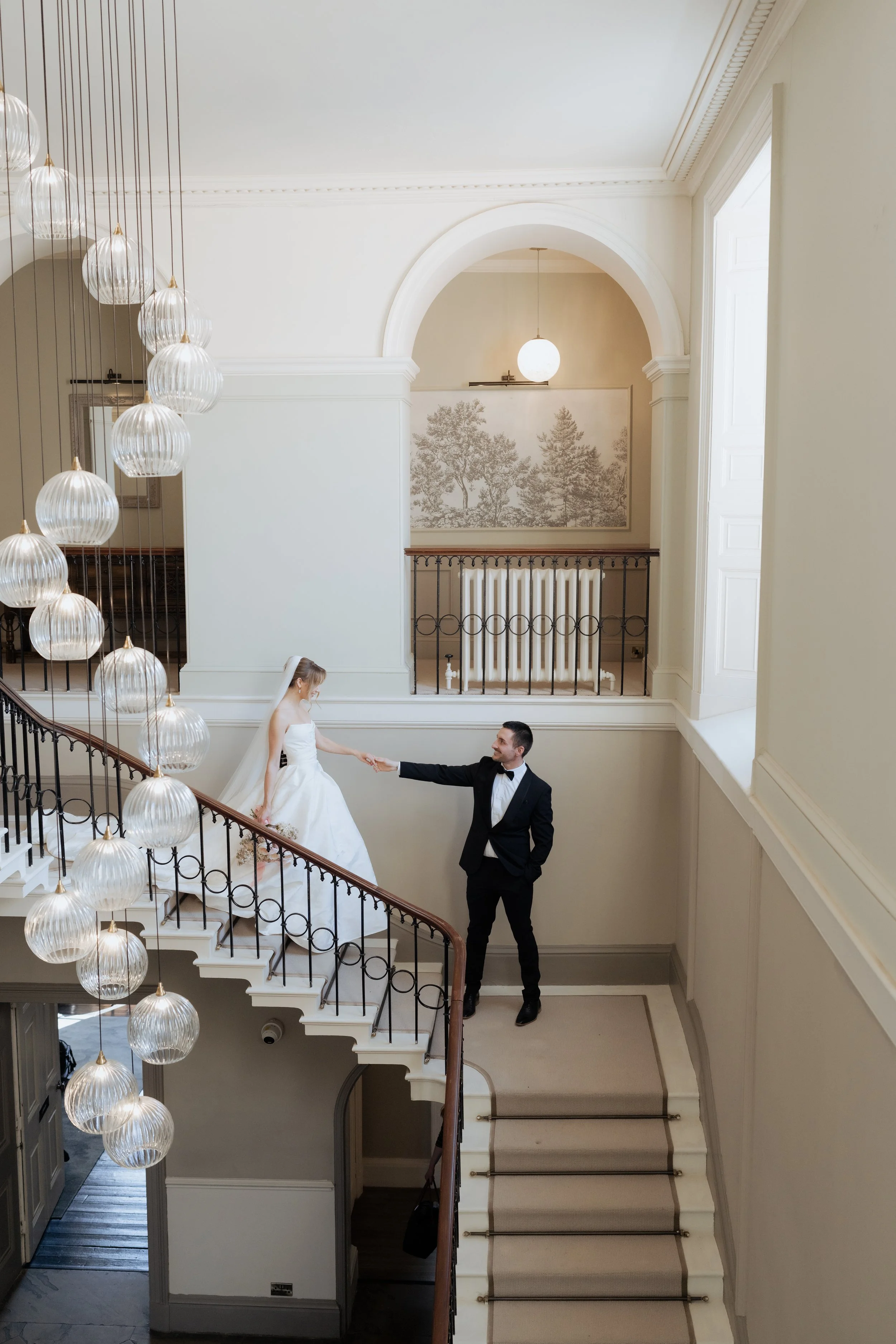  Bride and groom on staircase at Saltmarshe Hall, captured in a soft editorial wedding photography style with elegant architectural details