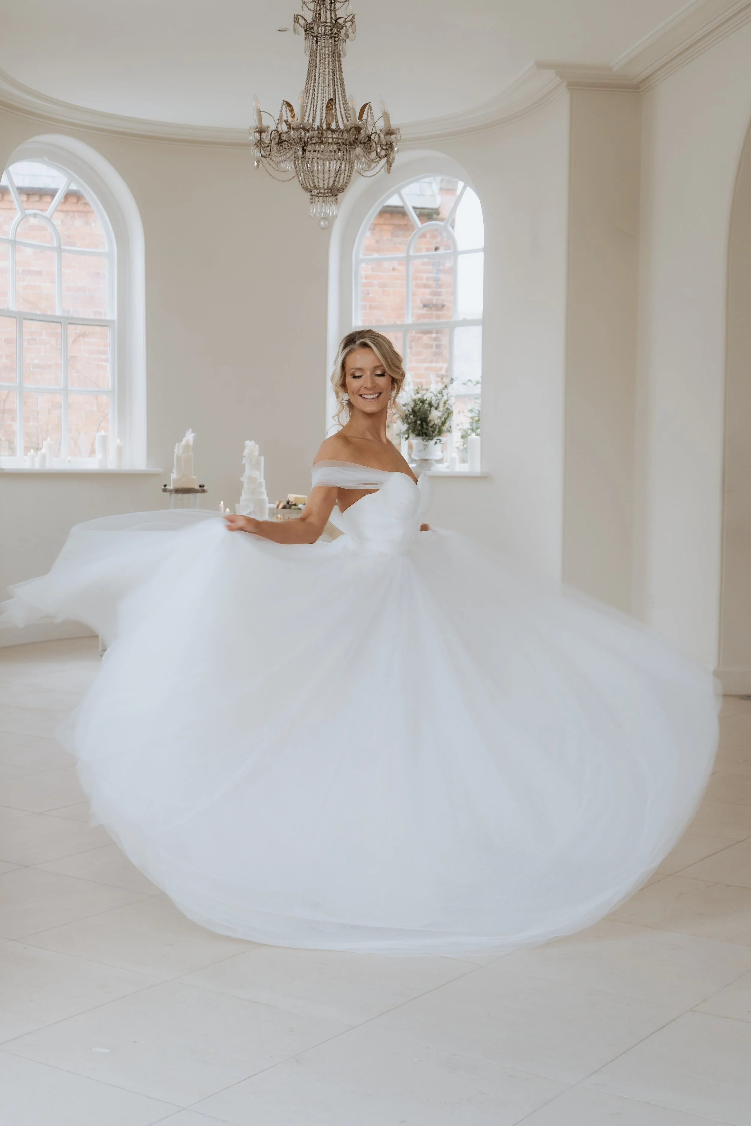 Bride twirling in a light-filled ceremony room inside Iscoyd Park, photographed in an editorial wedding style in Shropshire
