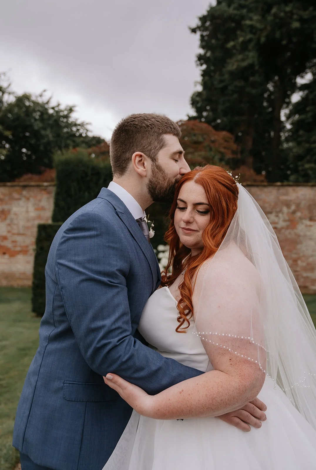 Romantic wedding portraits at Combermere Abbey featuring a modern couple in the formal gardens of the Cheshire wedding venue.