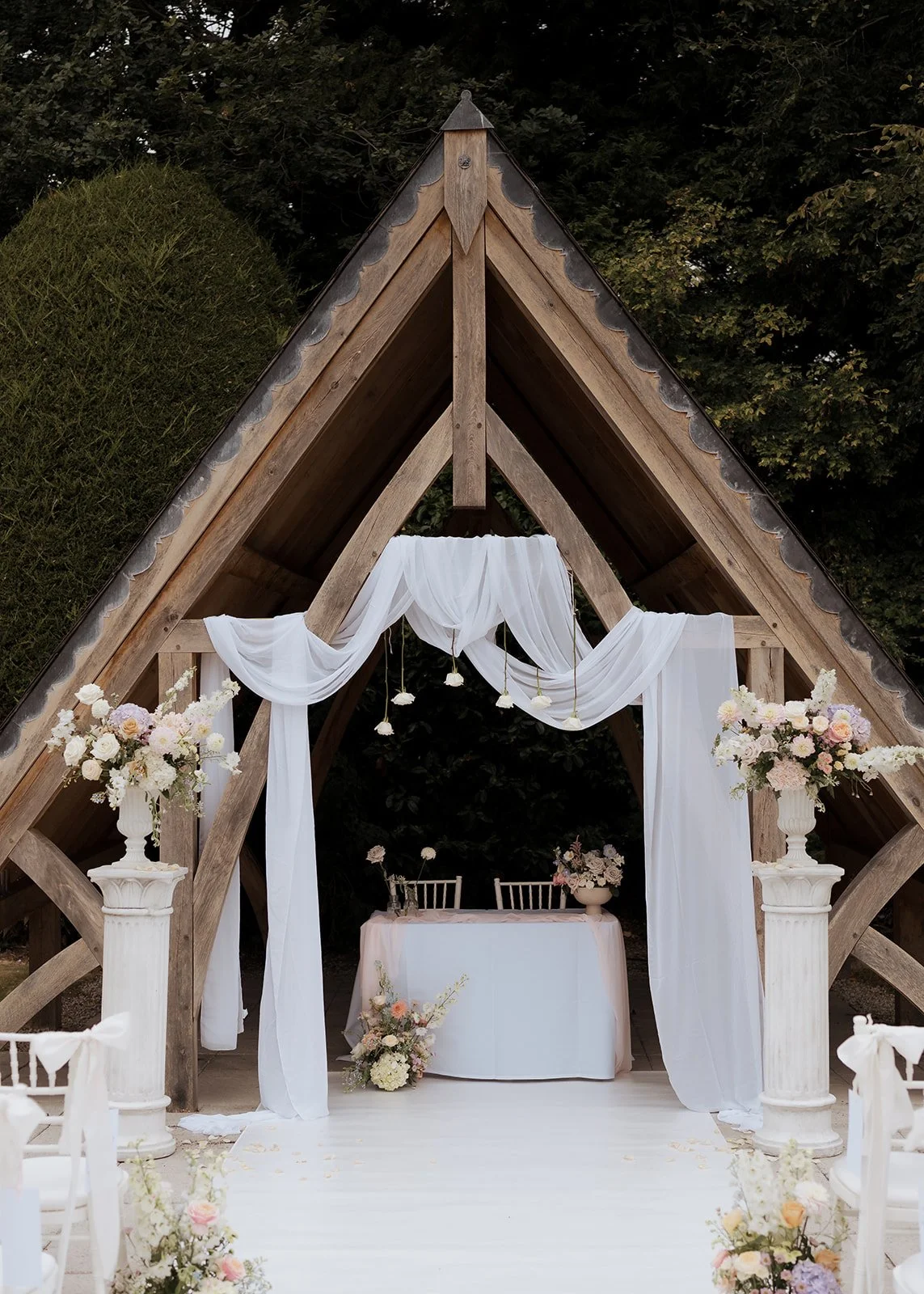 An outdoor wedding ceremony in North Wales, styled with soft draping and floral details, photographed with a calm, editorial approach.
