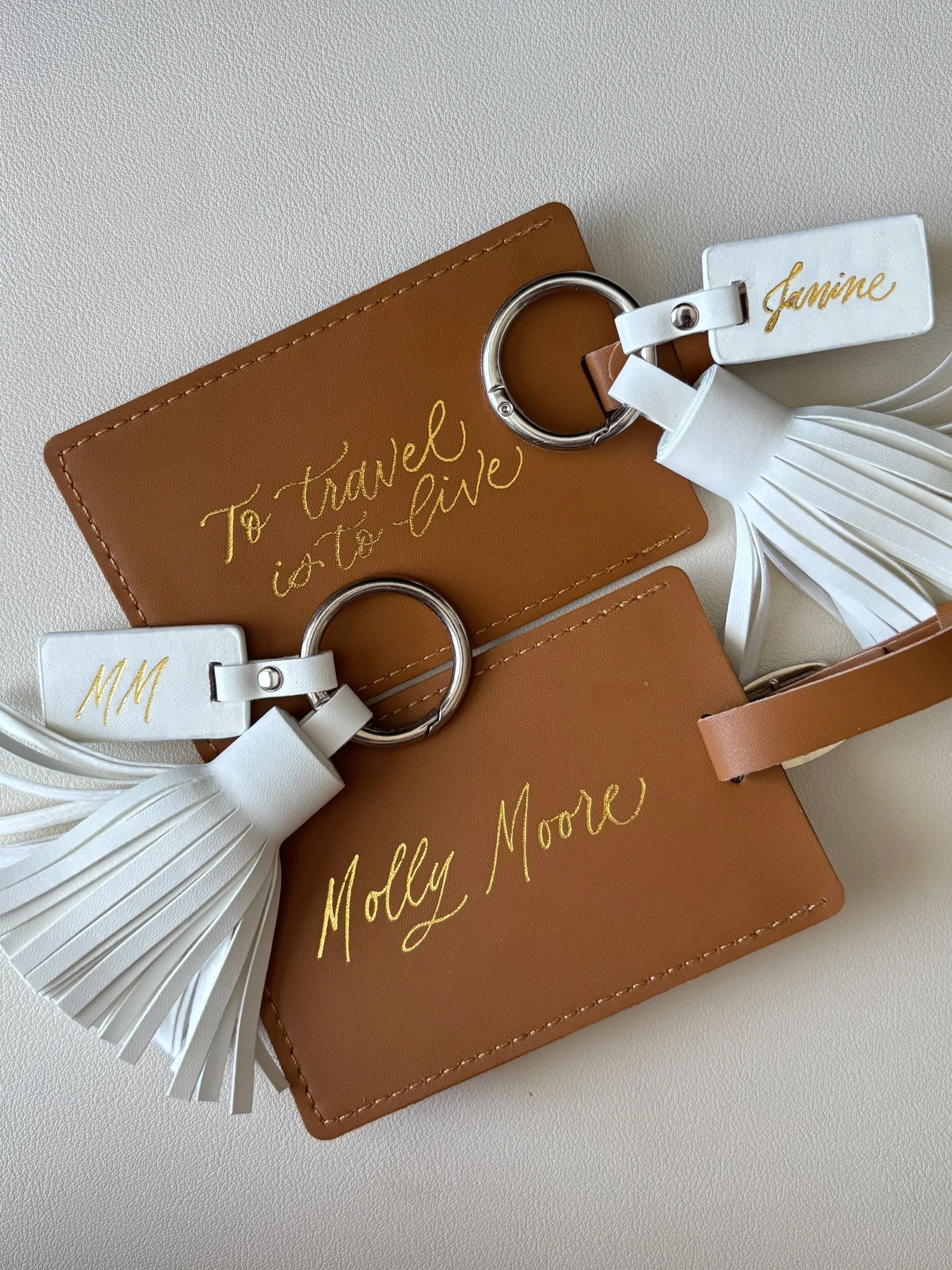 Two pineapple leather luggage tags and two white leather tassel keychains hot foiled in gold  calligraphy
