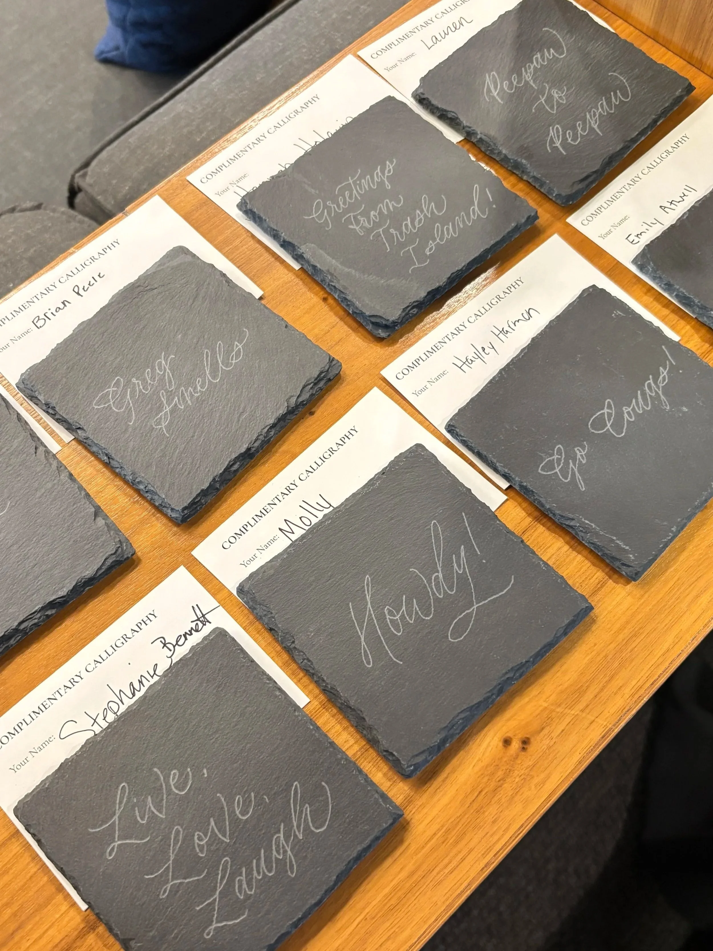 Several black slate coasters engraved in calligraphy