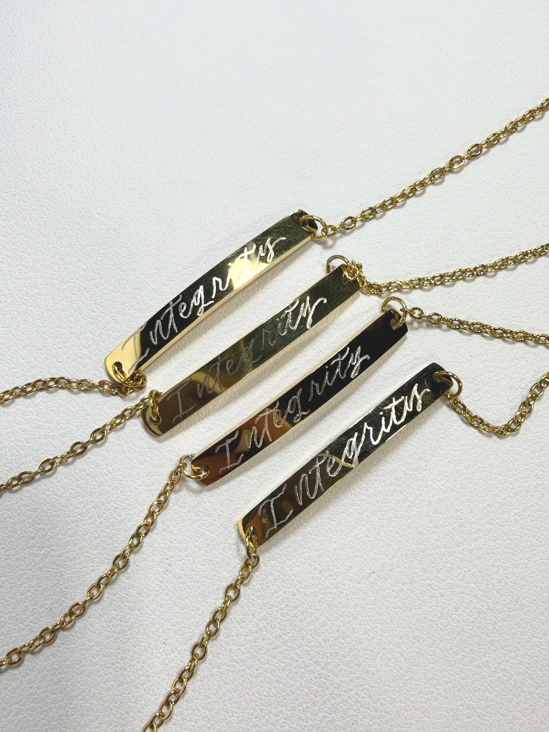 Four bracelets engraved with the word "integrity" in calligraphy