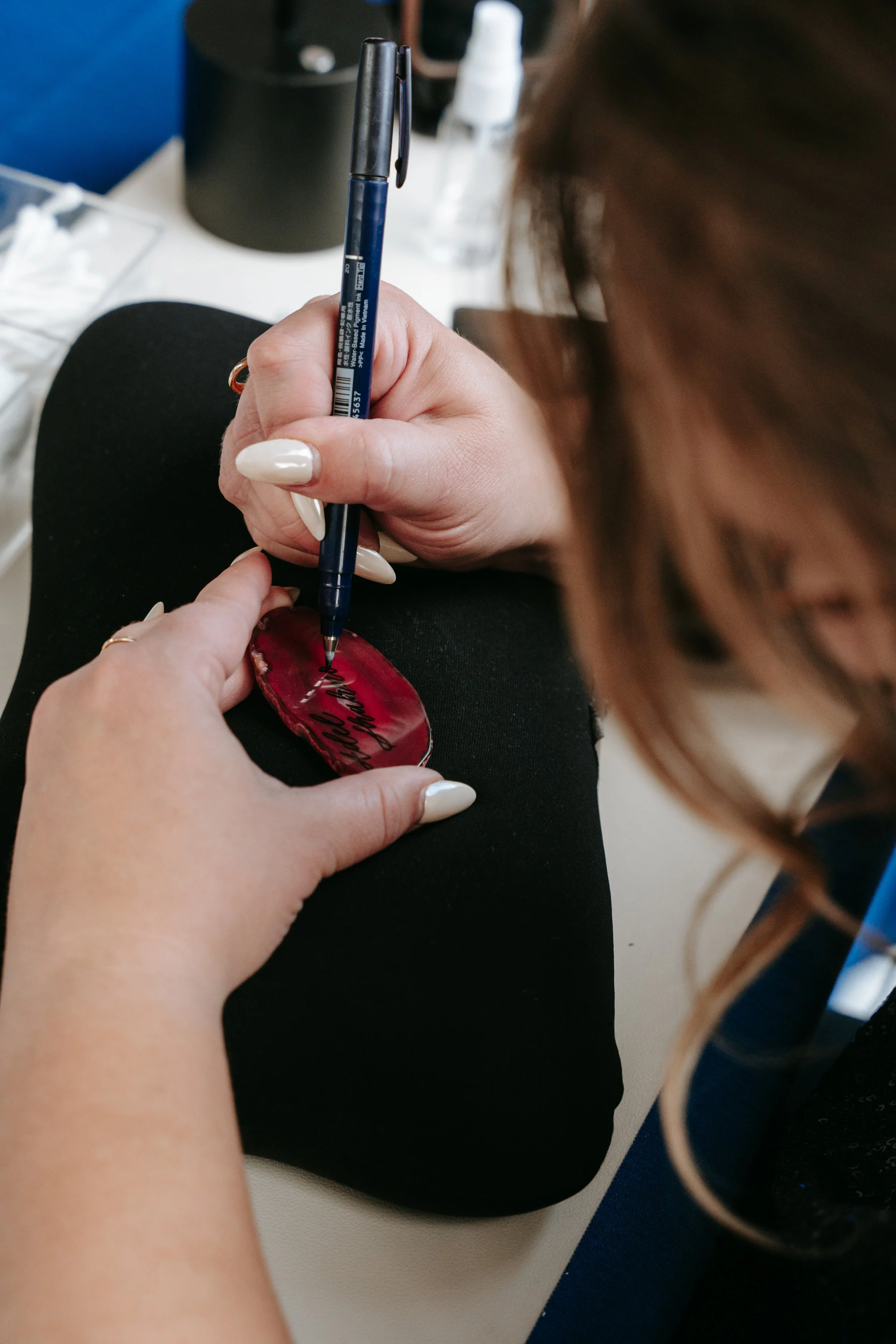 Alison is drafting a name for engraving on an agate slice for a wedding guest favor at a rooftop wedding in Denver, CO.