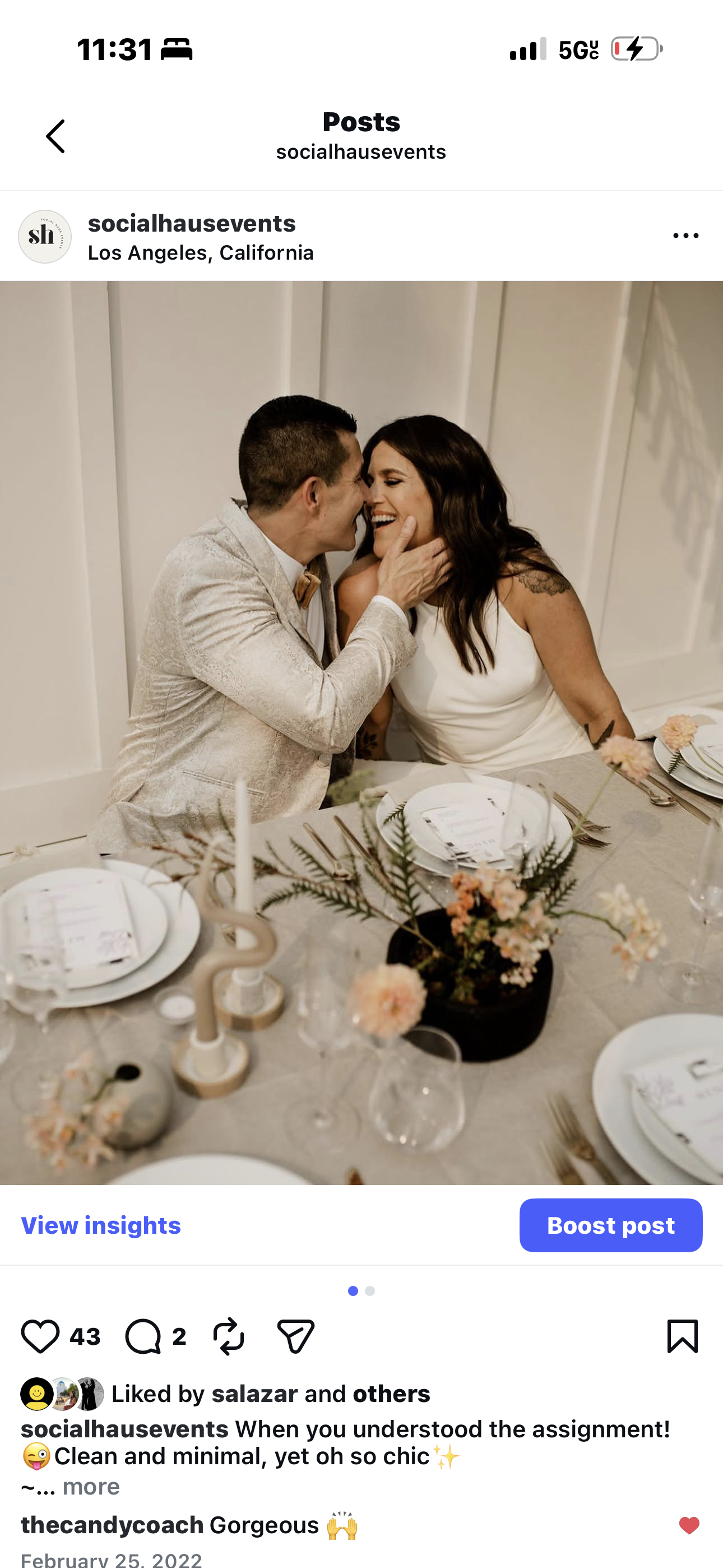 A couple sitting close at a decorated table, smiling and touching faces in a moment of affection, at a celebration or event in Los Angeles, California.