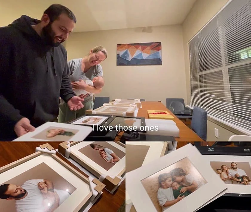Happy parents unboxing framed professional family and newborn photography at home.
