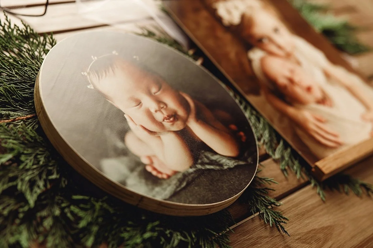 A professional round wooden photo block featuring a newborn baby in a "froggy" pose, displayed as part of a high-quality product collection from a Lake Oswego newborn photographer.