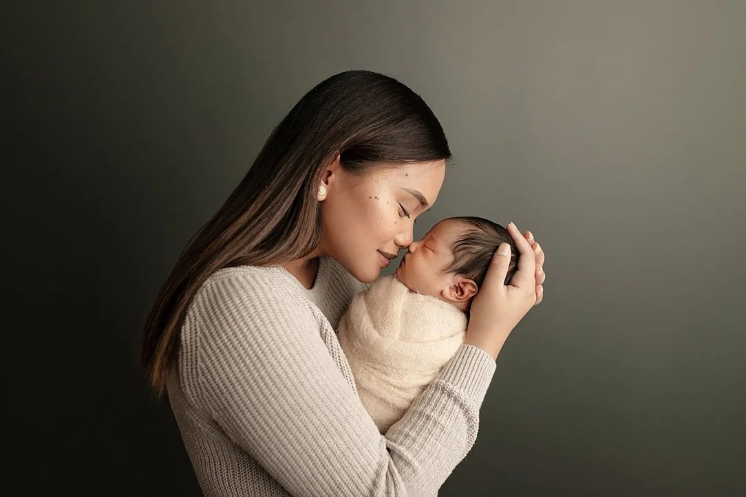 Professional "nose-to-nose" newborn and mother portrait photography in a studio setting.