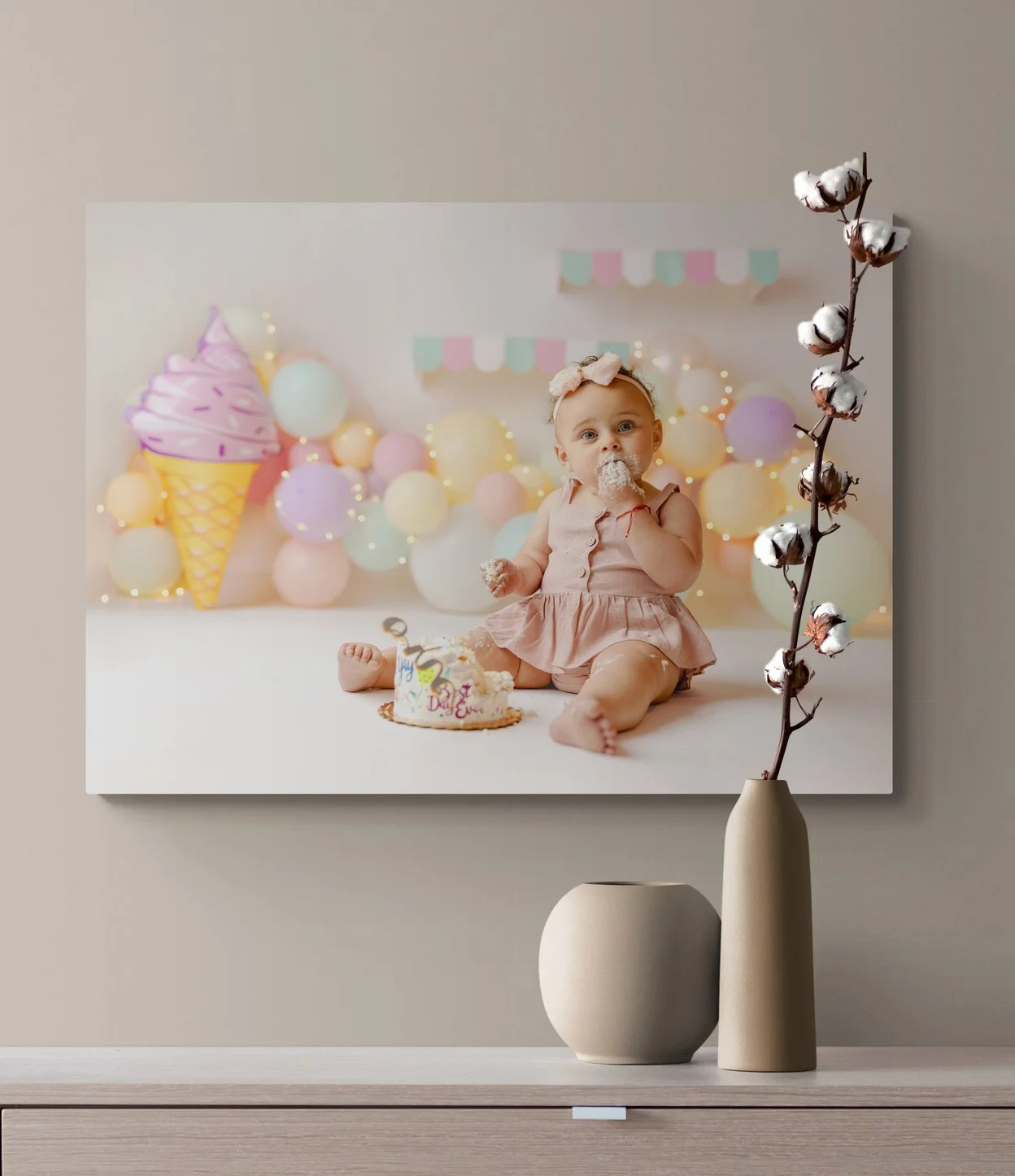 Fine-art canvas print mockup of an ice cream-themed first birthday cake smash session displayed over a modern wooden console table.