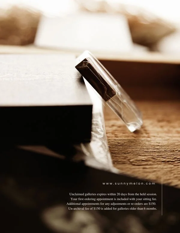 A professional close-up shot of a high-quality glass and metal USB drive resting against a sleek black presentation box, featuring the SunnyMelon Photography branding.