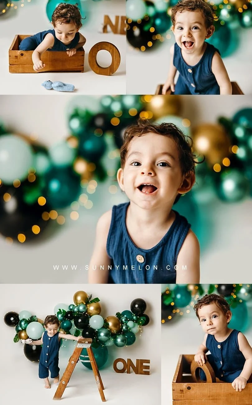 Toddler boy in a blue romper celebrating a "Wild One" jungle-themed first birthday in a professional photography studio.