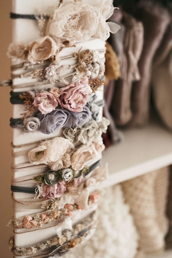 Handmade floral newborn headbands and delicate lace hair accessories displayed in a Portland baby photography studio, featuring soft pink, lavender, and neutral tones.