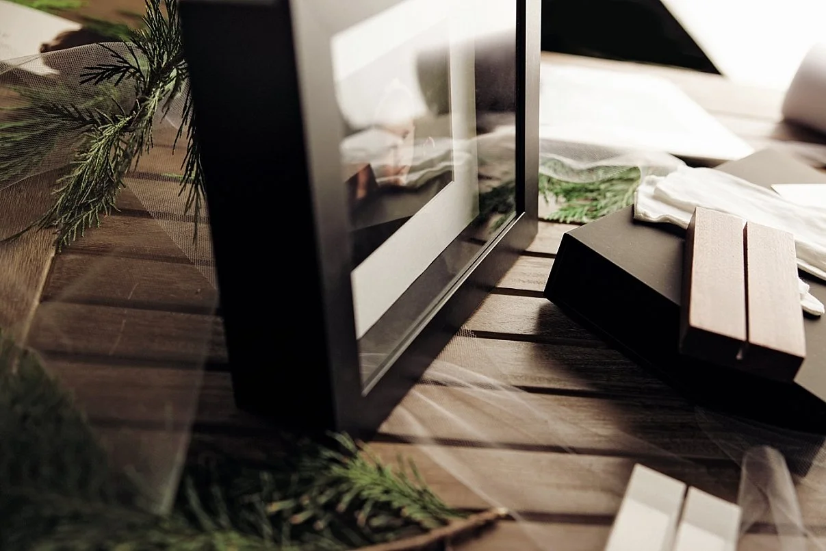 Close-up of a framed photograph print displayed by Sunnymelon Photography in Portland, Oregon, with festive greenery and packaging details on a wooden table.