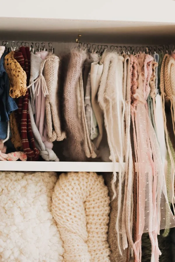 Close-up of neutral and pastel colored knits, lace wraps, and blankets used for newborn baby photography sessions in Portland, Oregon.