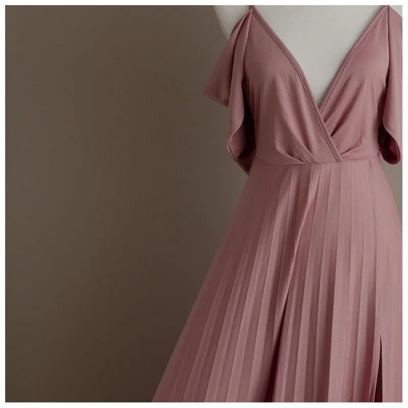 A close-up of a dusty mauve maternity gown from a West Linn studio client closet. Displayed against a taupe background, it features a v-neck bodice and pleated skirt, highlighting high-end portrait wardrobe options.