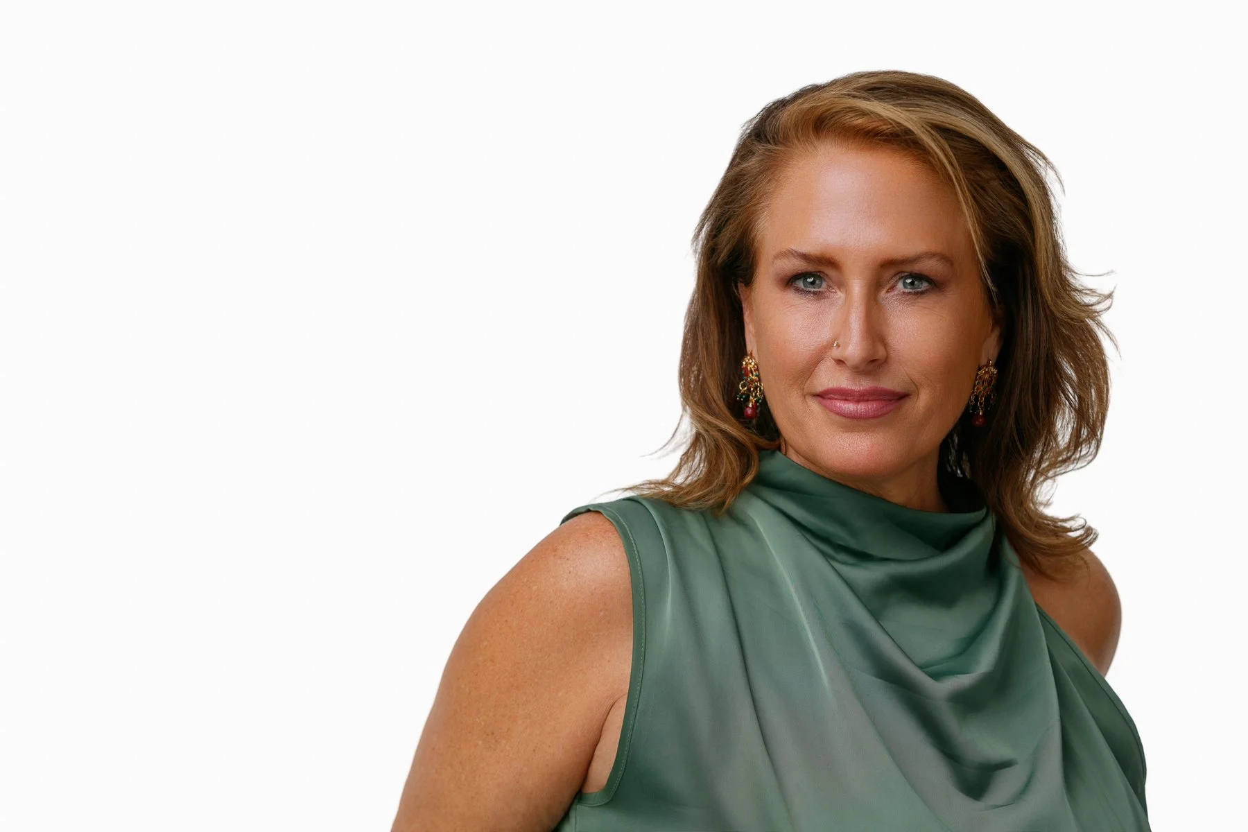 Close-up of a woman with shoulder-length brown hair, blue eyes, and light makeup, smiling softly against a blue background.