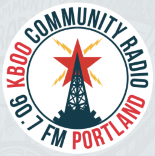 This is the logo for KBOO Community Radio, Portland, Oregon, USA.  It shows a radio tower in bluish-green in a middle circle, which has an outer ring saying Kaboo Community Radio (with 'Kaboo' in red); the tower has a red star; white background