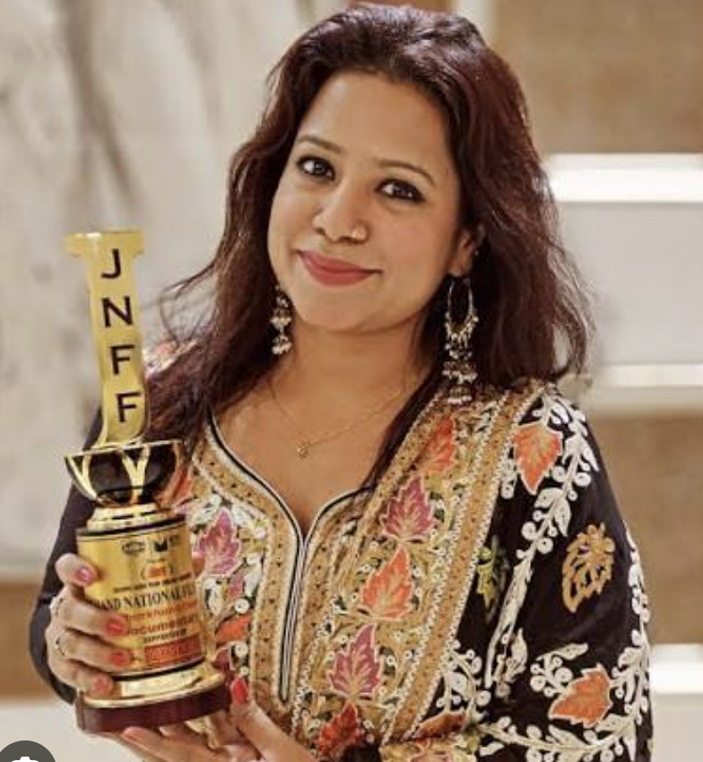 An Indian woman  with untied hair standing with a trophy