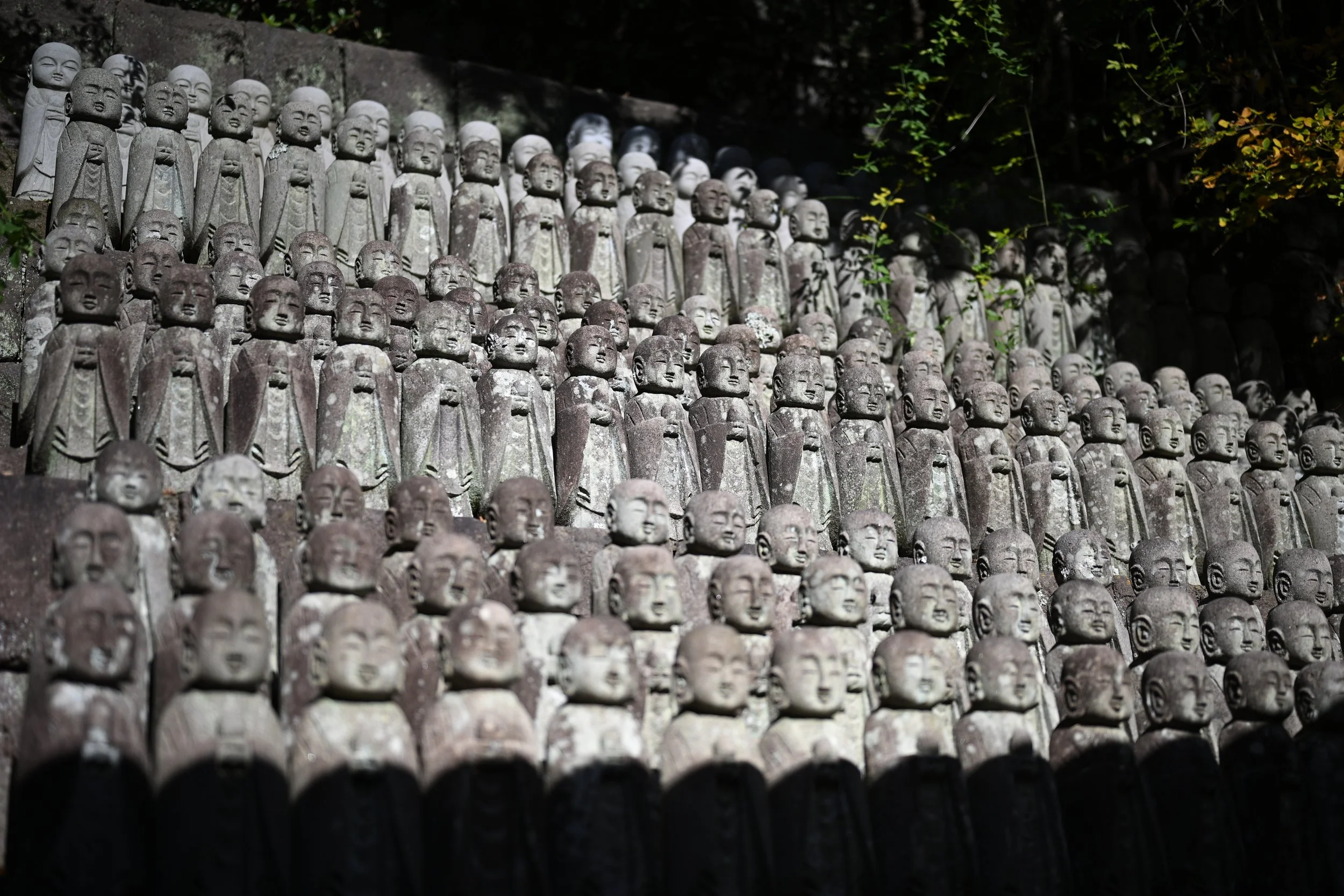 They are called Jizo statues. Jizo is the guardian deity of children. Historically, parents came to Hasedera to set up these statues in hopes the deity would protect and watch over their children.
