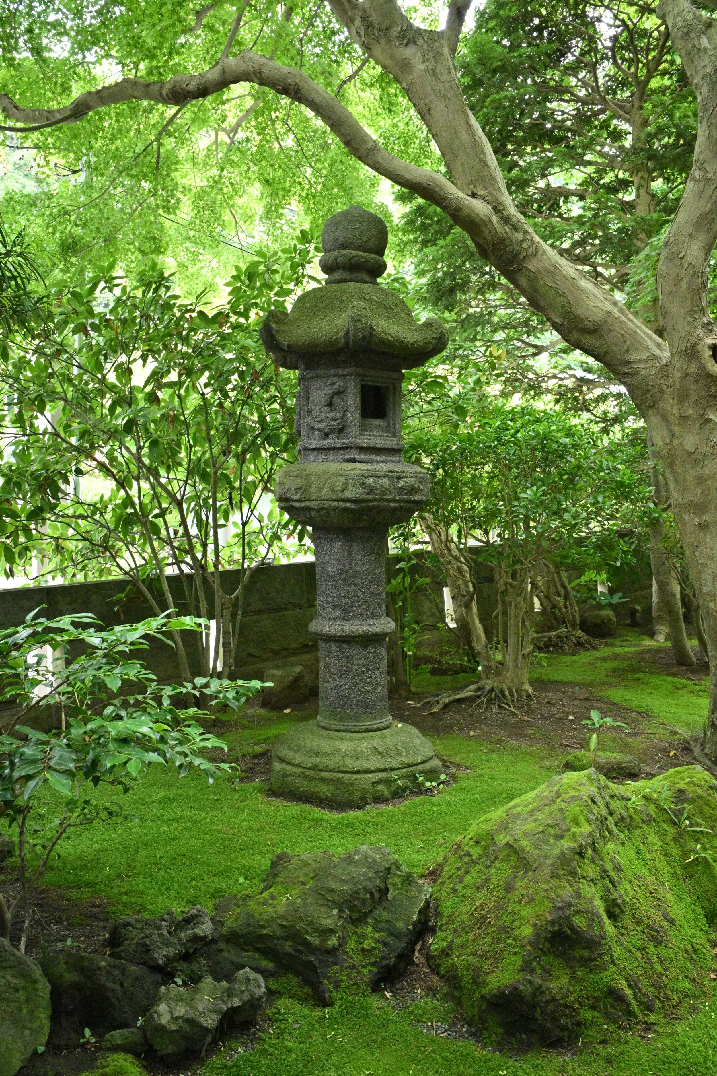 Design Styles: The specific large, heavily mossed lanterns with tiered, pagoda-style roofs found at Hokokuji often fall under the Tachigata (pedestal) or Yukimi-gata (snow-viewing) styles of stone lanterns