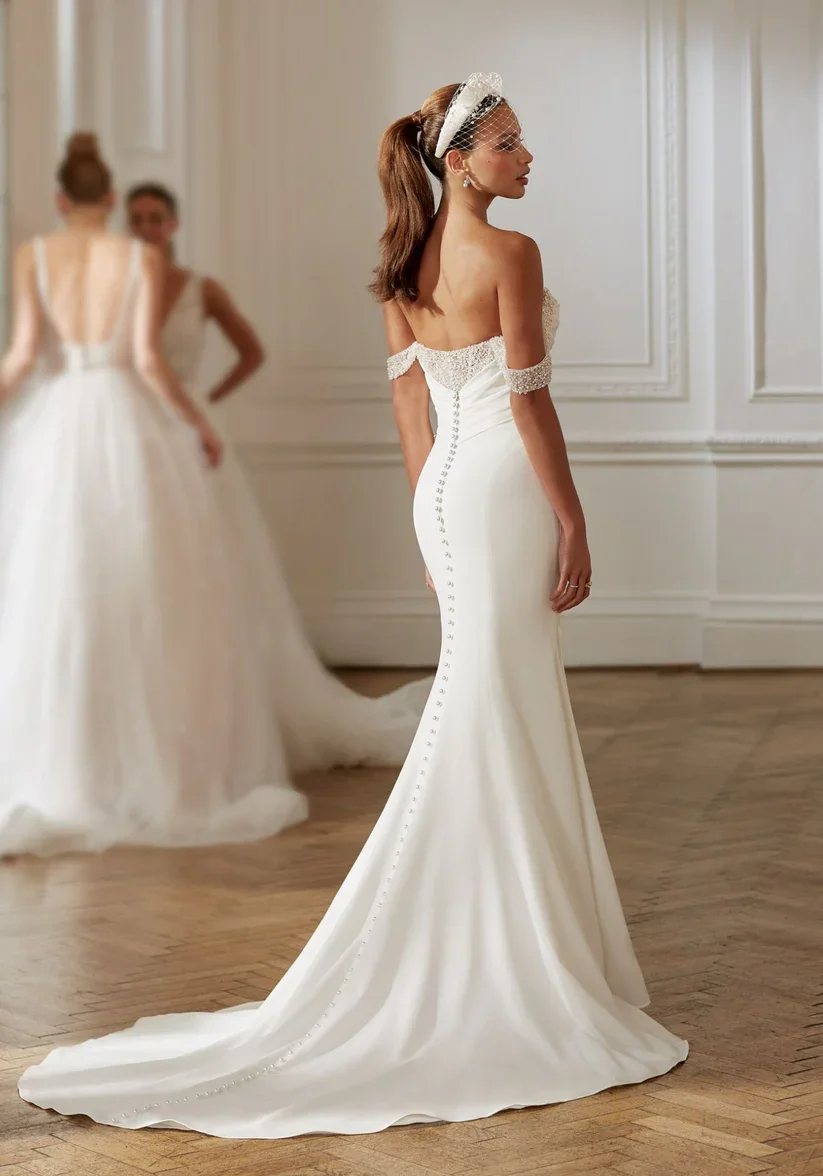 A classic wedding dress crafted from fine crepe, with delicate beading, she is a versatile gown for an array of ceremonies and receptions.