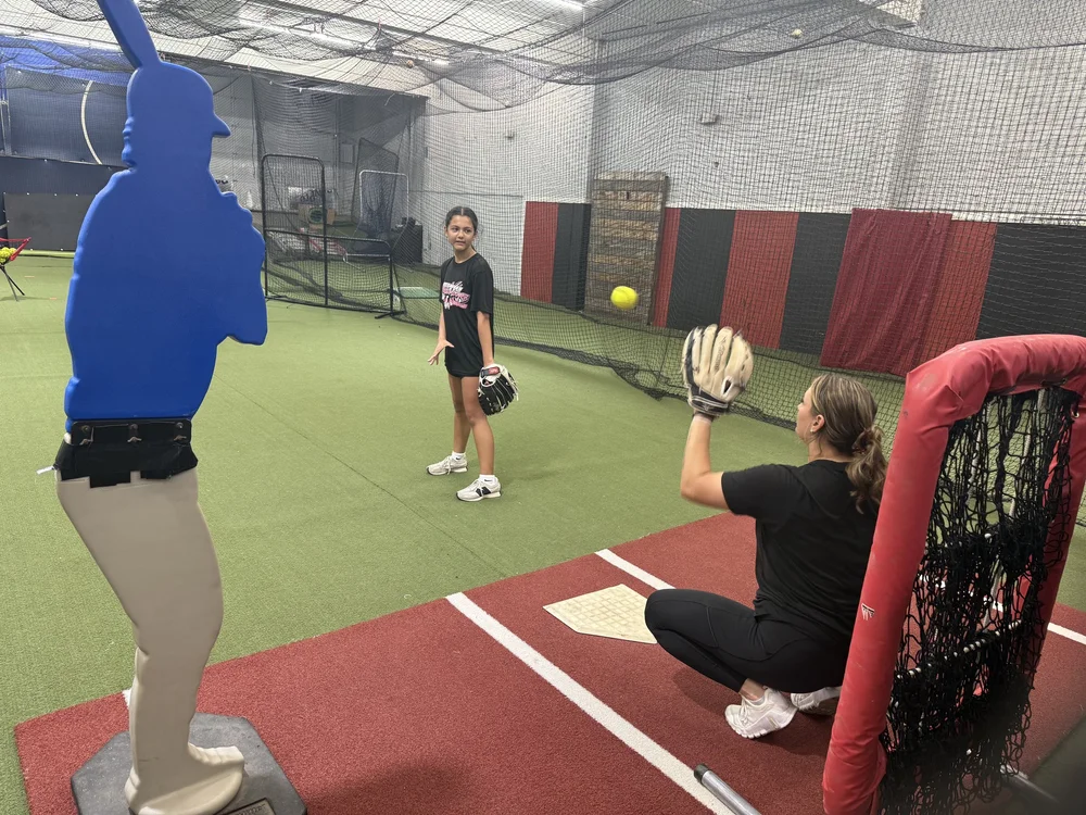Softball pitcher practicing with a coach inside Swing Zone
