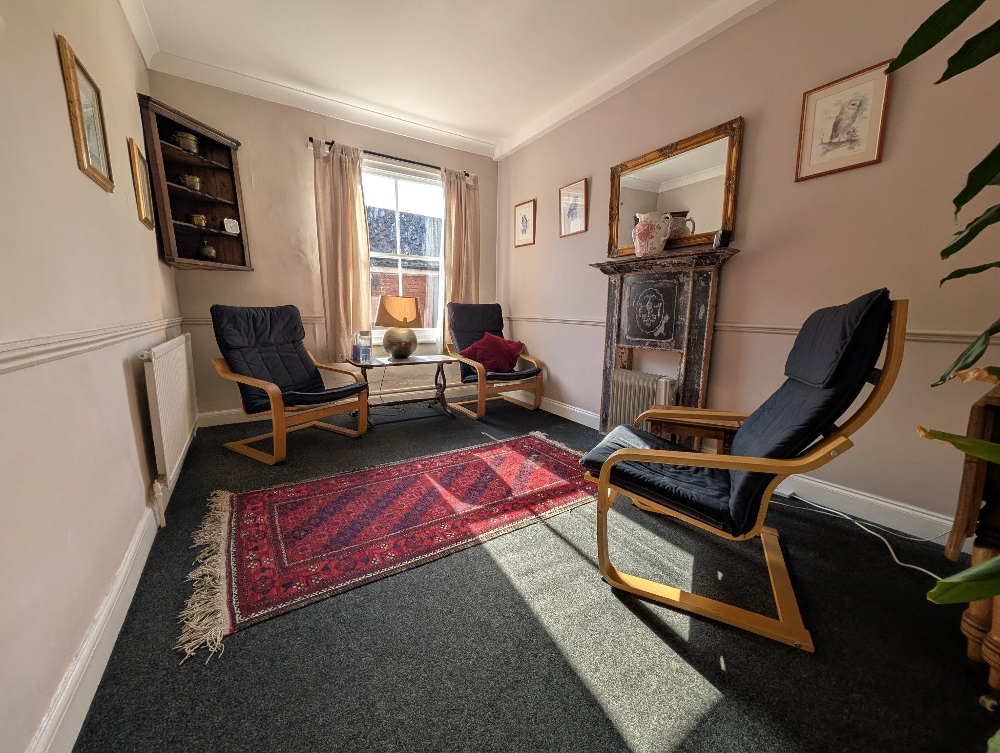 Counselling room at The Practice Rooms in Norwich, with three chairs and a fireplace