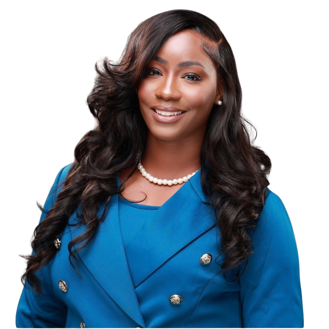 Shalea Dowdy  with long, wavy black hair, wearing a blue double-breasted blazer, pearl necklace, and pearl earrings, smiling against a black background.