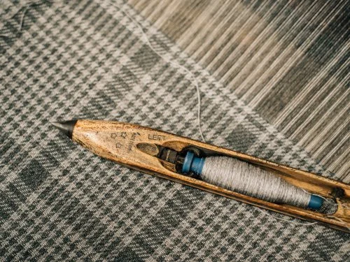 traditional flying shuttle in wooden loom ( kharga) while weaving Symrik Coat scarf