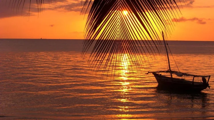 Sonnenuntergang mit Dhau vor der Küste Sansibars