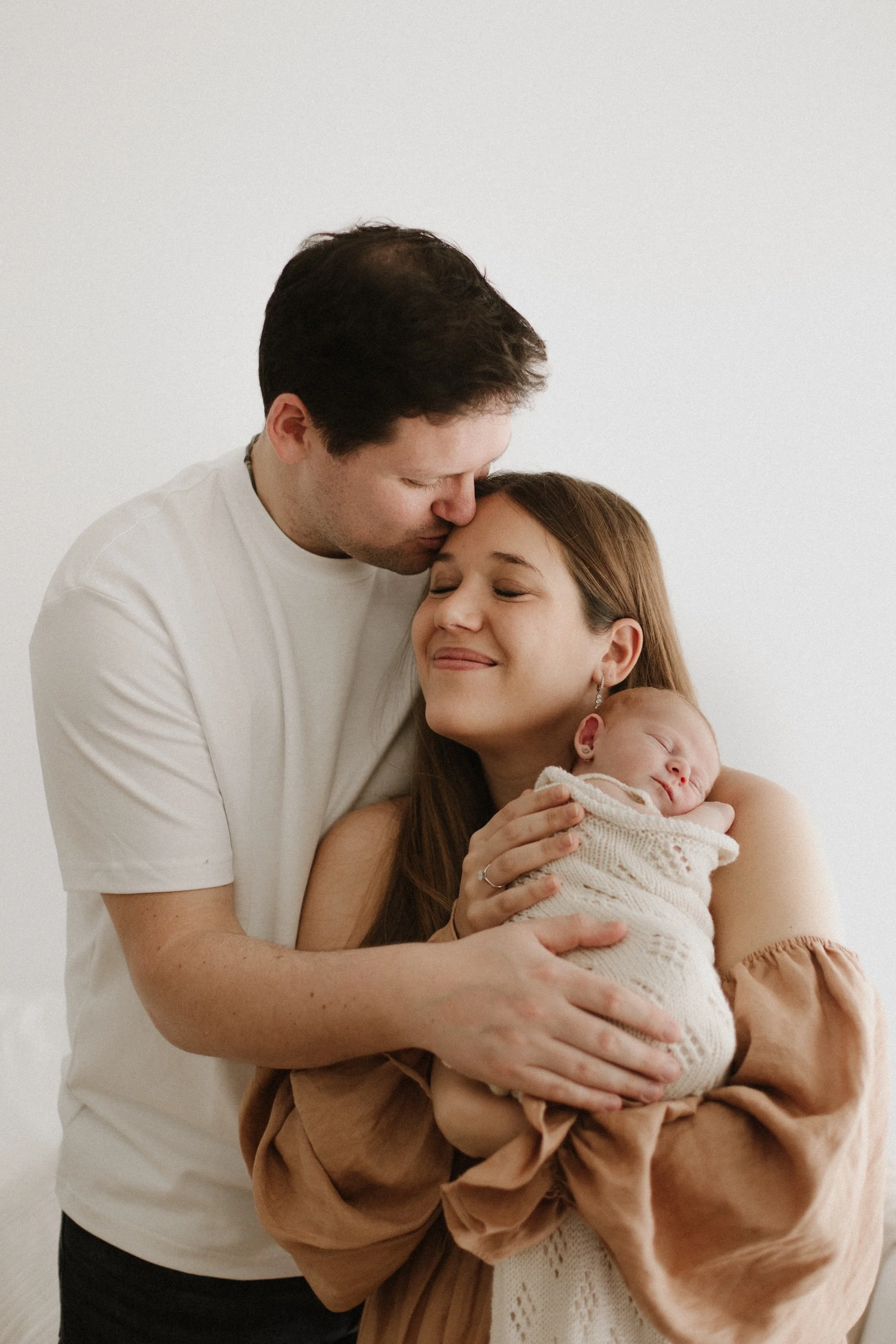 Baby newborn during photoshoot in a timeless white setting